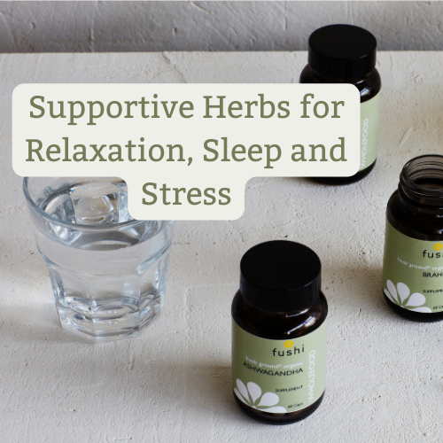  Two dark brown bottles with "fushi" labels, suggesting health supplements, possibly Ashwagandha and Brahmi, known for their stress-relieving properties. There's also a glass of water, all placed on a textured white surface. Overlay text reads "Supportive