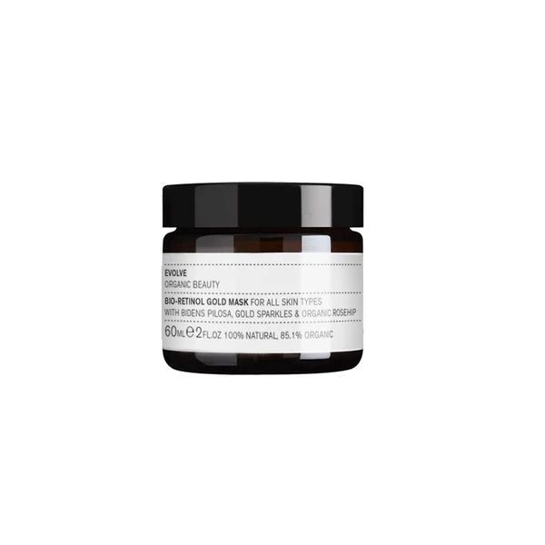  A small glass jar with a black lid, housing "EVOLVE ORGANIC BEAUTY BIO-RETINOL GOLD MASK," suitable for all skin types, 60ml. The label is white with black text, detailing its natural and organic ingredients, against a white backdrop.