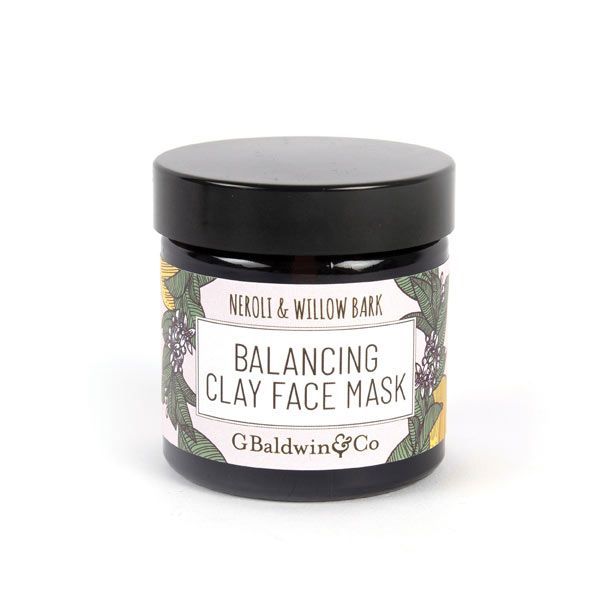 A glass jar with a black lid, labelled "Neroli & Willow Bark BALANCING CLAY FACE MASK" by G. Baldwin & Co, featuring botanical illustrations around the label. The product is in a 60ml container and is presented against a white background.