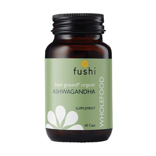 A bottle of Fushi brand "fresh ground organic ASHWAGANDHA WHOLEFOOD SUPPLEMENT" with 60 capsules. The bottle is dark amber with a green label, featuring a graphic of ashwagandha roots and a small yellow flower, indicating a natural health product.